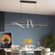 Modern luxury linear wave LED pendant light above dining table