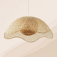 Handcrafted natural bamboo pendant light with a woven curved shade in a modern living room