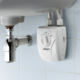 Lorenzetti Versátil 5700W instant electric undersink water heater installed beneath a bathroom washbasin