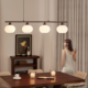 Vintage 4-light pendant chandelier with white glass globe shades and a dark linear metal frame